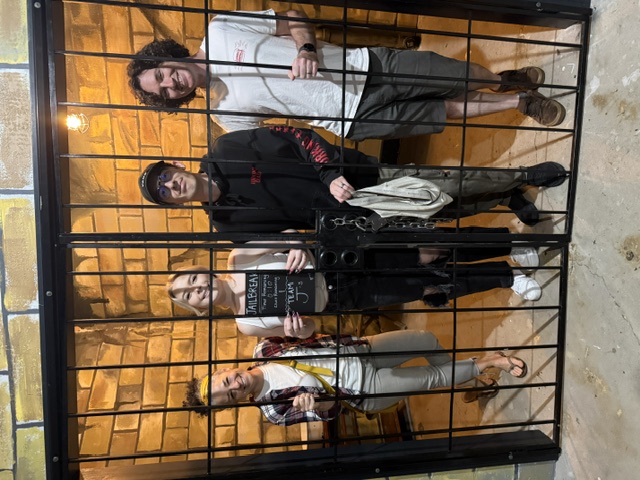 Players posing behind the Jail Break bars