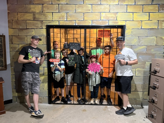 Family celebrating in front of the Jail Break cell