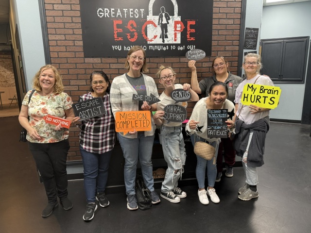 Team holding celebration signs at Greatest Escape